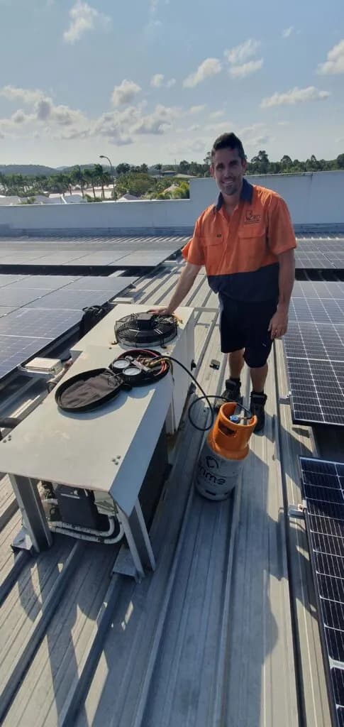 A HVAC technician repairing an air conditioning unit of the roof of a hotel