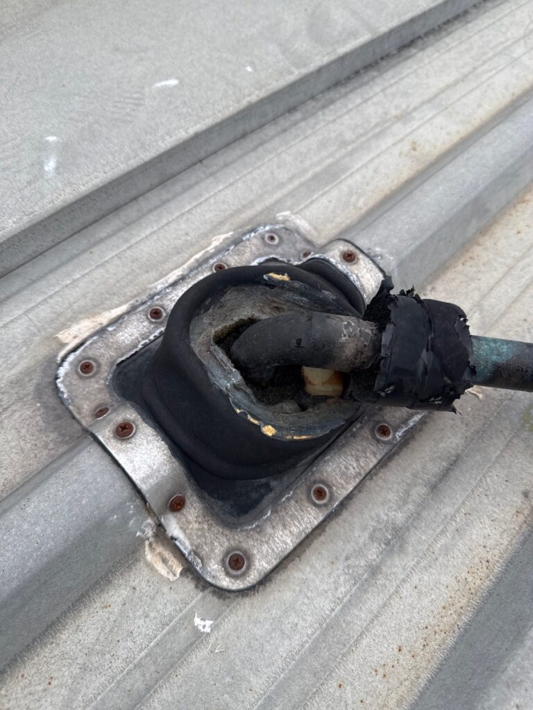 Dektite roof penetration with cracked and degraded seal due to prolonged UV and weather exposure in Queensland climate.